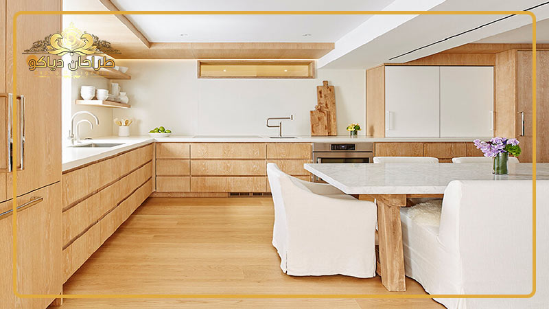 نمای یک آشپزخانه با رنگ روشن و کابینت های چوبی.